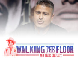 Man with raised hands at a film festival event with Walking the Floor graphic at bottom.
