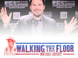 Man's face in close-up against a blurred festival backdrop with Walking the Floor graphic below.