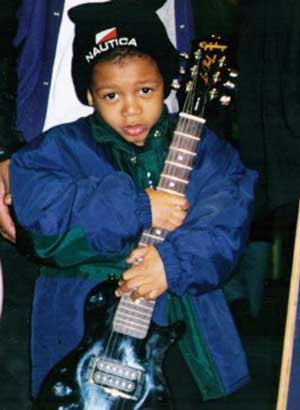 A young shopper holds an Epiphone Les Paul at zZounds Music Discovery Center