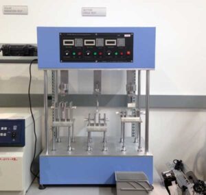 A button cycle testing machine with blue frame and control panel.