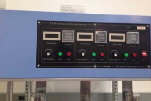 The testing machine control panel features displays and colored indicator lights.