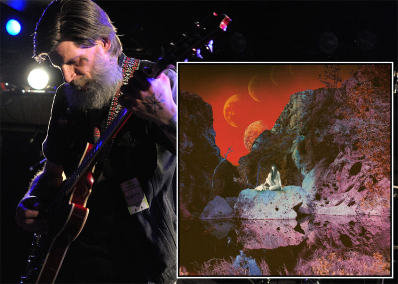 A bearded musician plays guitar on stage left; right shows an alien landscape with floating spheres.