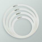 Four white Remo drum dampening rings nested in decreasing sizes.