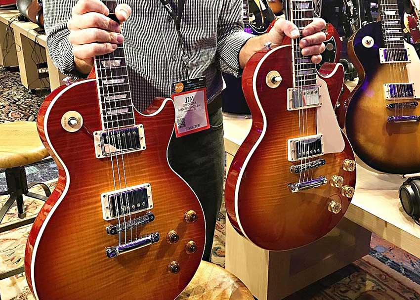 Gibson Head Luthier Jim DeCola holds up both a Traditional and High Performance 2016 Les Paul Standard at NAMM 2016.