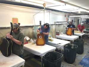 Gibson factory workers adding some final touches before the bridges are attached.