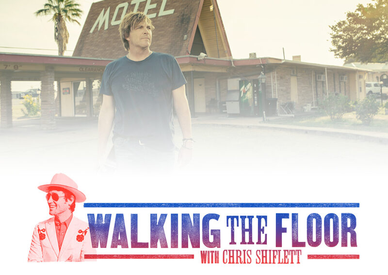 Man in blue shirt stands outside rundown motel for Walking the Floor promotion.