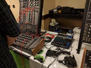 Large modular synthesizer featuring extensive red, green, and blue patch cable interconnections.