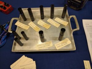Metal trays display cylindrical electronic components with SleeperySupply labels and product identification tags.