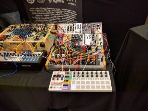 Complex modular synthesizer with multiple colored patch cables interconnecting various electronic modules.