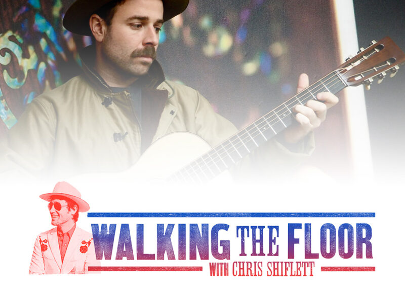 A bearded man plays an acoustic guitar in the Walking the Floor podcast branding.