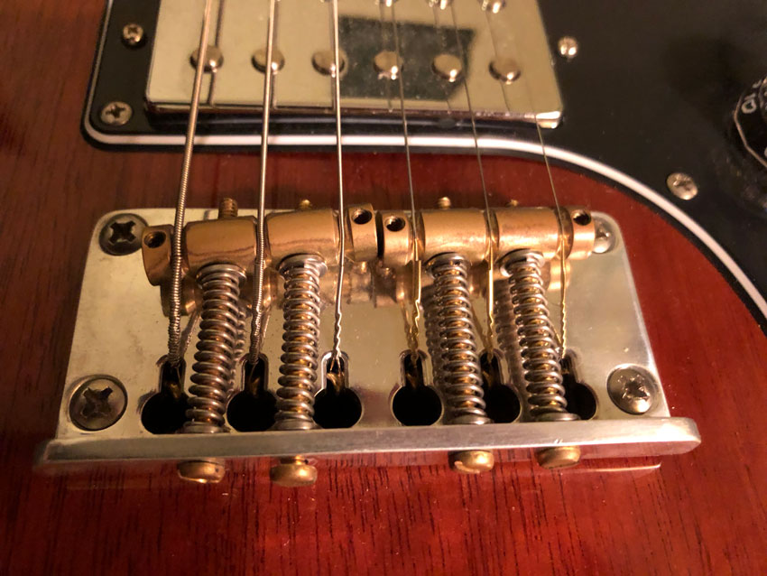 Bridges with barrel saddles, like the PRS Plate-style bridge shown here, may require a hint of compromise.