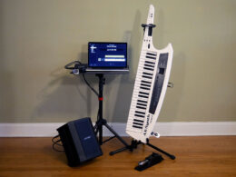 A wireless MIDI keyboard rig includes a laptop, keyboard controller, amplifier, and wireless receiver on a stand.