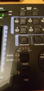 A lighting control panel with channel buttons and controls for program, music, pan, tilt, mode.