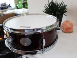 Completed black snare drum with white head and chrome hardware.