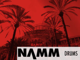 Section banner at NAMM displays Drums label in red.