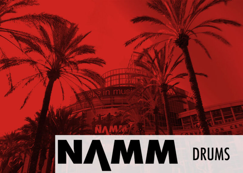 Section banner at NAMM displays Drums label in red.