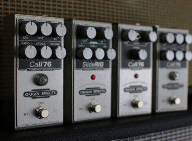 Four Origin Effects guitar pedals including Cali76 and SlideRIG arranged in a row.