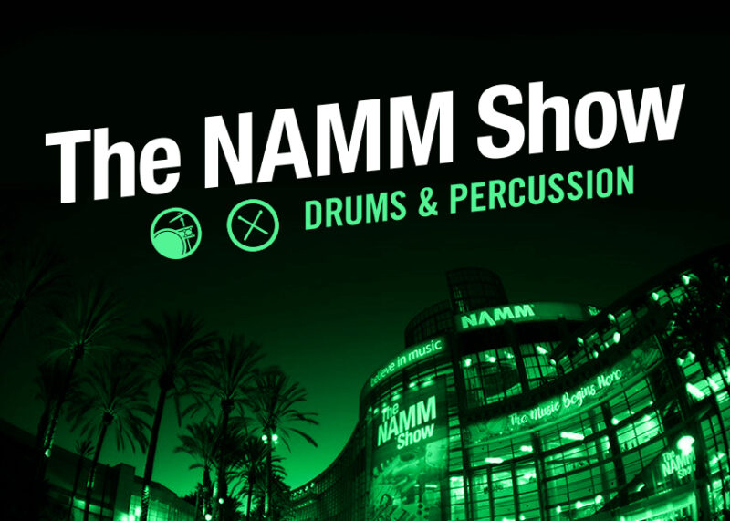 Green neon lights highlight drums and percussion instruments at The NAMM Show.
