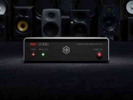 ARC STUDIO audio correction device is positioned in front of an array of professional studio monitor speakers.