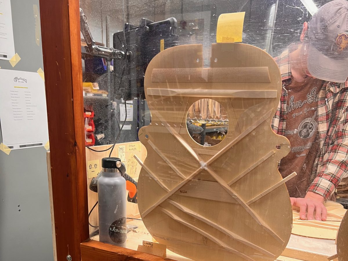 A luthier at work in the Martin factory crafting scalloped bracing.