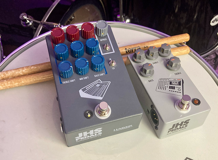 The JHS Colour Box V2 Anniversary Edition and a JHS 424 GainStage pedal resting on a snare drum.